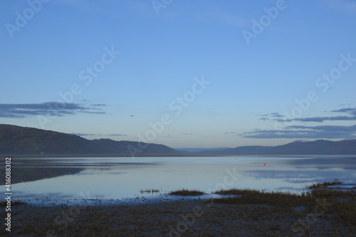 a view of the welsh mountains from ynyslas beach reflected in the estuary