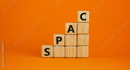 SPAC, special purpose acquisition company symbol. Businessman holds cubes with word 'SPAC' on beautiful orange background, copy space. Business and SPAC, special purpose acquisition company concept.
