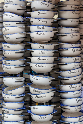 Display of traditional breton painted bowls customized with names. Shopping in Brittany, France