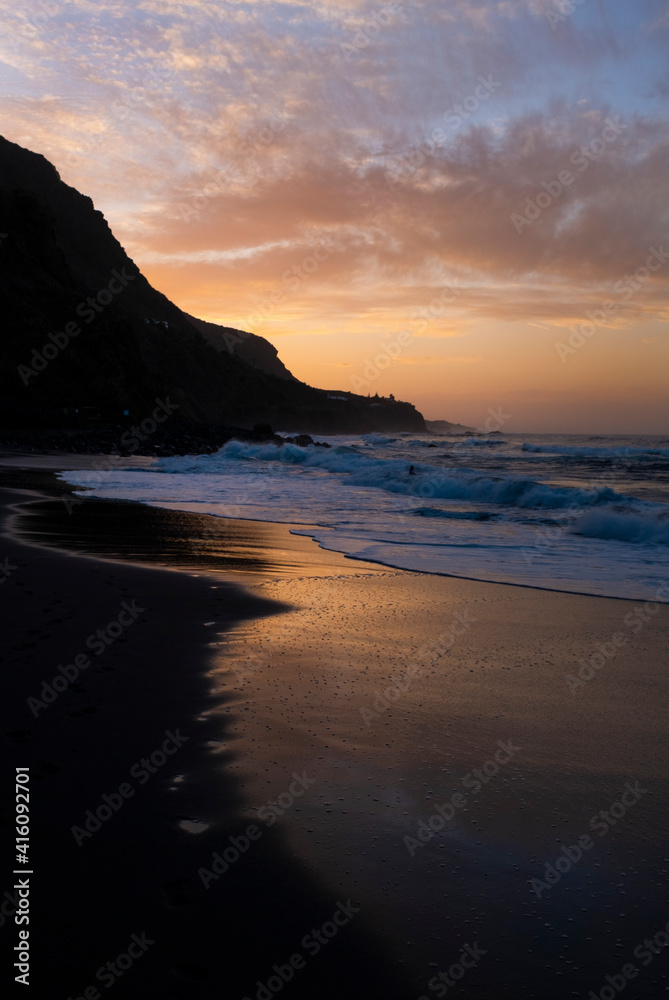 Beautiful beach shore landscape at sunset time with dusk and down evening - beach in the dark and colorful sky in background