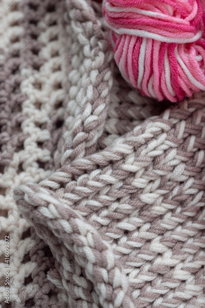 Close up colorful yarn texture background, brown beige pink and white strains. Shallow depth of focus. Knitting and crochet, craft work hobby concept. Winter clothes. Trendy styling color combination.