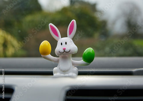 Obraz na płótnie Easter bunny with easter eggs solar powered toy in car window interior w salonie