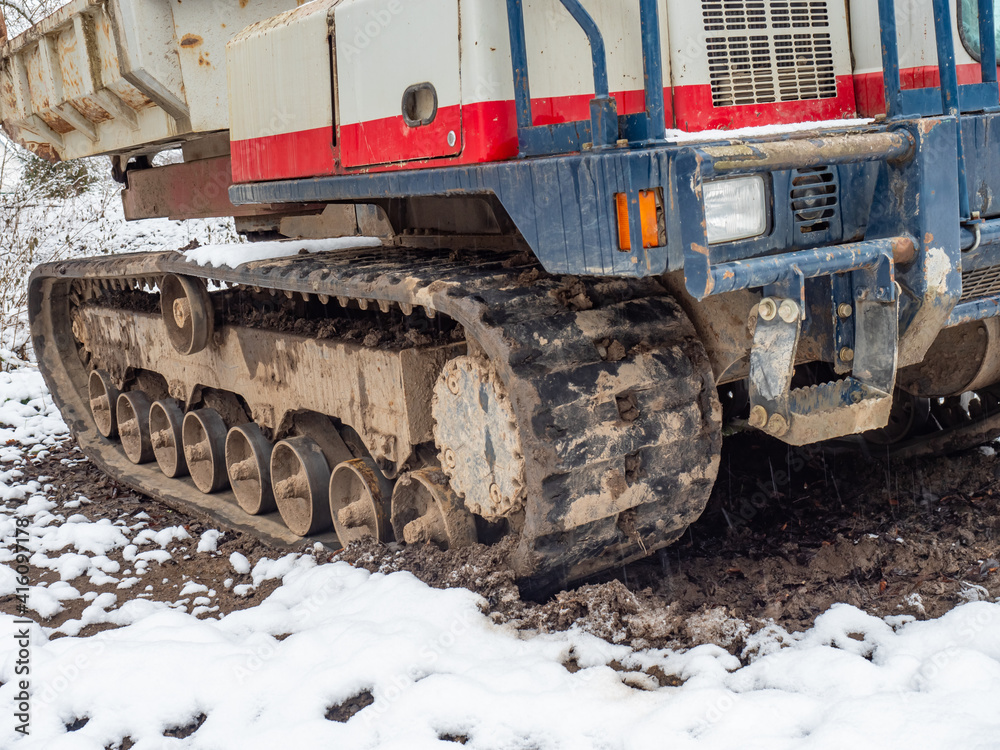 Tracked dump truck with a steel body for transporting stones, soil or sand over difficult terrain.