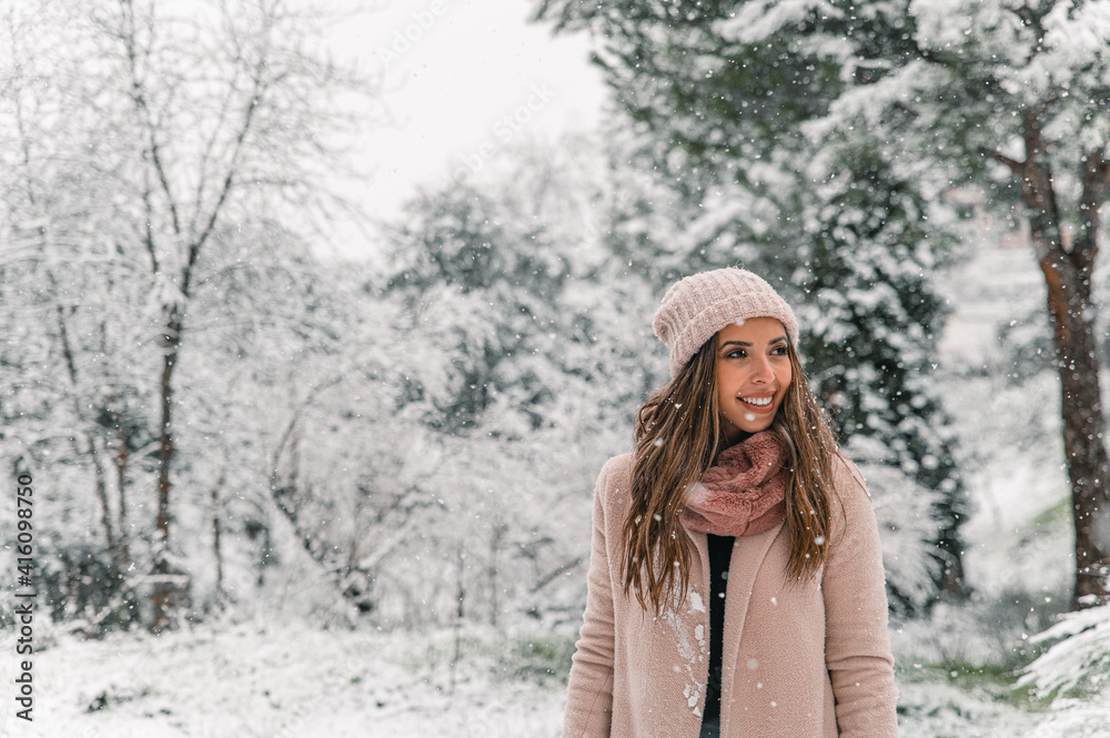 Smiling woman standing in winter forest