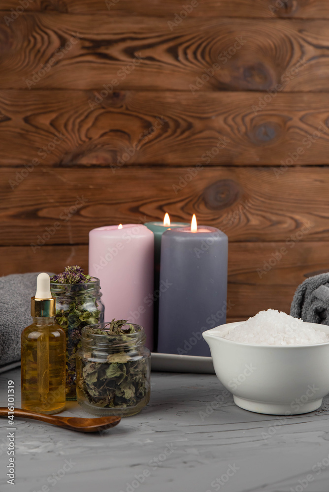 Herbal therapy, traditional medicine and homeopathy concept. Towel with salt, herbs, candles and bottle natural organic oil essence serum. Set for spa, massage and aromatherapy Herbal therapy, traditional medicine and homeopathy concept. Towel with salt, herbs, candles and bottle natural organic oil essence serum. Set for spa, massage and aromatherapy
