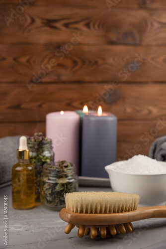 Herbal therapy  traditional medicine and homeopathy concept. Towel with salt  herbs  candles and bottle natural organic oil essence serum. Set for spa  massage and aromatherapy