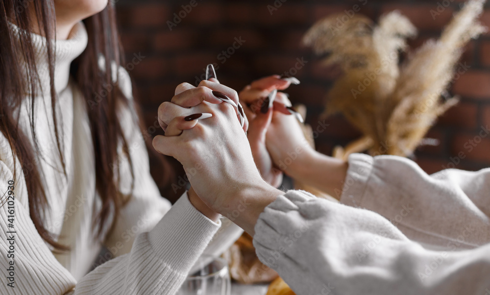 Obraz premium Man and woman holding hands together at restaurant, closeup