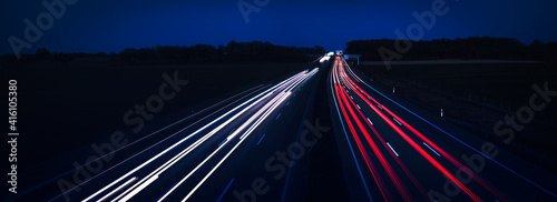 Panorama of the night autobahn, highway. Light lines from cars.