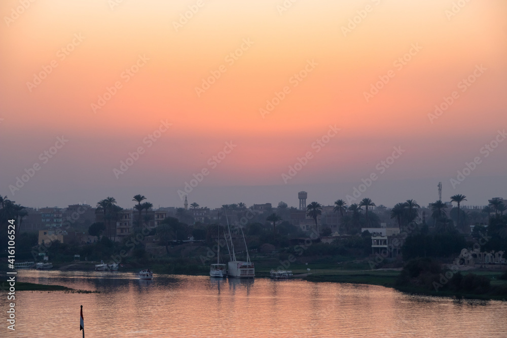 sunset with Nile river  from Luxor, Egypt. orange sky reflected over the Nile river. 