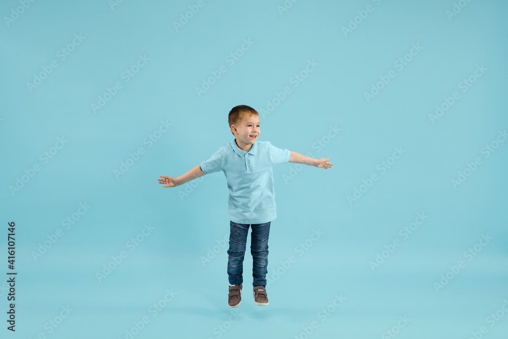 Childhood and dream about big and famous future. Pretty little boy isolated on blue studio background. Dreams, imagination, education, facial expression, emotions concept. Copyspace. Childhood and dream about big and famous future. Pretty little boy isolated on blue studio background. Dreams, imagination, education, facial expression, emotions concept. Copyspace.