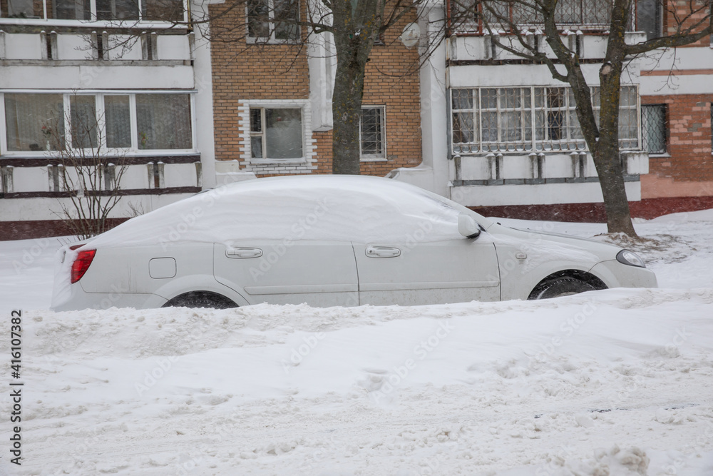 Cars are covered with snow. The blizzard brought a lot of snow. Winter city.