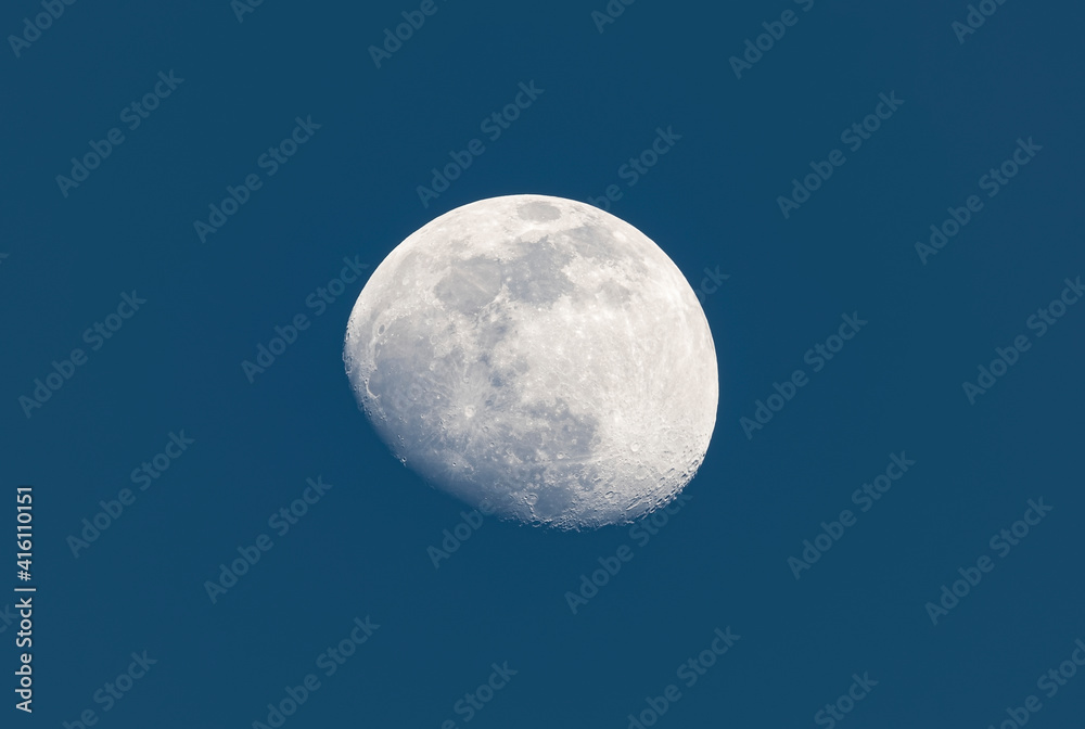 Stunning close up view of a crescent moon with detailed craters during daylight. Dark blue sky with copy space. Stunning close up view of a crescent moon with detailed craters during daylight. Dark blue sky with copy space.