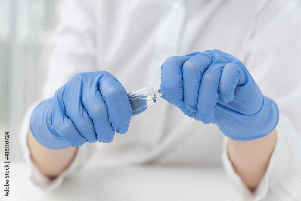 doctors hands hold transparent amoule with vaccine, ready to break it. Actions before injection. Vaccination concept doctors hands hold transparent amoule with vaccine, ready to break it. Actions before injection. Vaccination concept