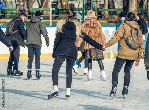 Rear view with people enjoying ice skating on the Cismigiu ice rink, in Bucharest. photo