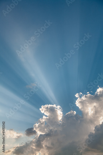 Obraz na płótnie A sky with white clouds and beautiful sunbeams passing through the clouds. The magical beauty of the sky with the sun and clouds w salonie