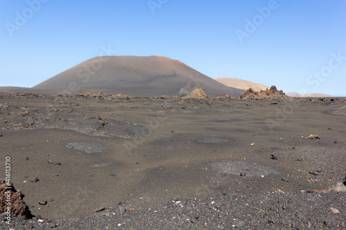 Black ground volcanos in Timanfaya National Park. Volcanic natural landscape in Lanzarote island. Travel destination, tourism attraction concepts