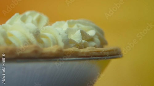 [Camera Used: Canon C300] Close-up, low angle, rotating pumpkin pie loaded with fluffy whipped cream! Check out this seller's other videos for more variation of this clip from the same series! photo