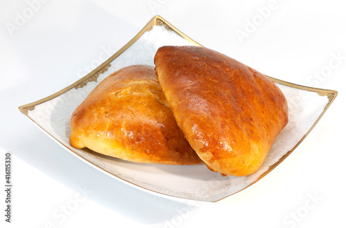 two baked kulebyaki with fish on a plate