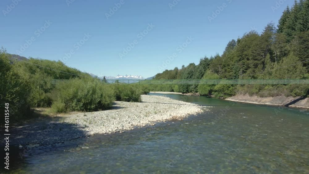 Aerial parallax of Rio Azul river and elevated bridge surrounded by trees and mountains, Patagonia Argentina Aerial parallax of Rio Azul river and elevated bridge surrounded by trees and mountains, Patagonia Argentina