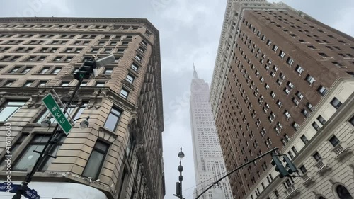 Herald Towers and Empire State Building 34th Street upward angle view snowing in winter storm Manhattan New York City NYC