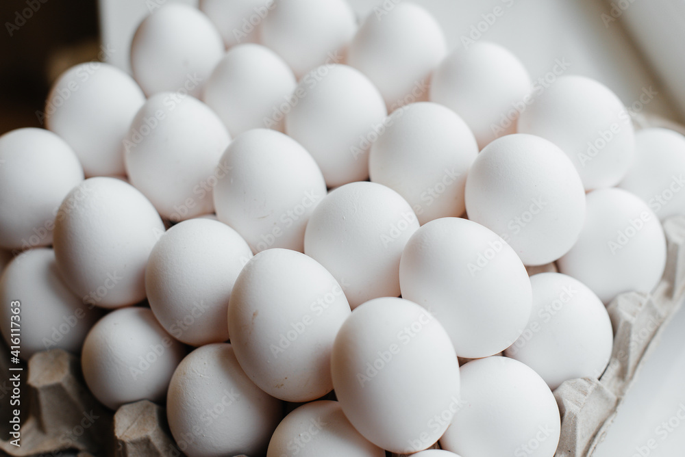 Tray of white fresh eggs close-up on a cardboard form. Agricultural industry