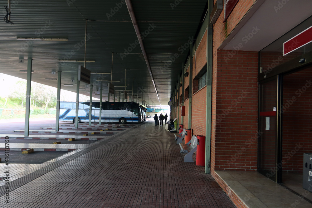 Exterior of a small bus station with buses waiting