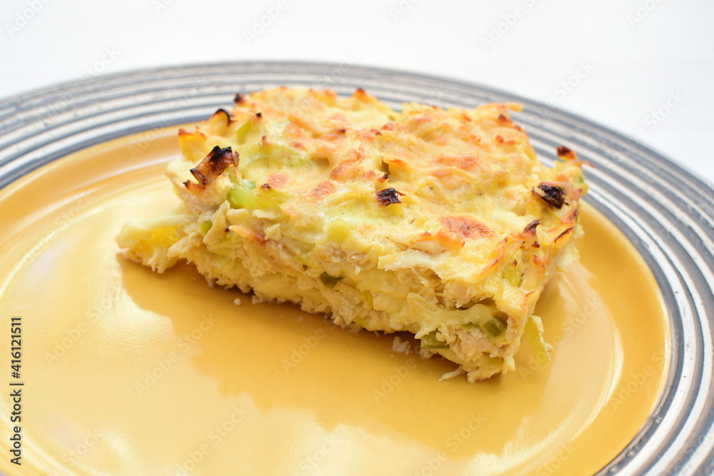 Baked chicken and mushroom cannelloni, bathed in cream in cheese sauce gratin on white wooden background