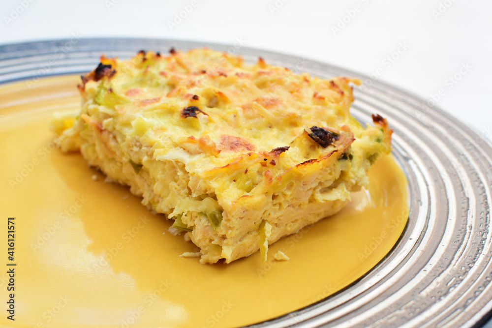 Baked chicken and mushroom cannelloni, bathed in cream in cheese sauce gratin on white wooden background