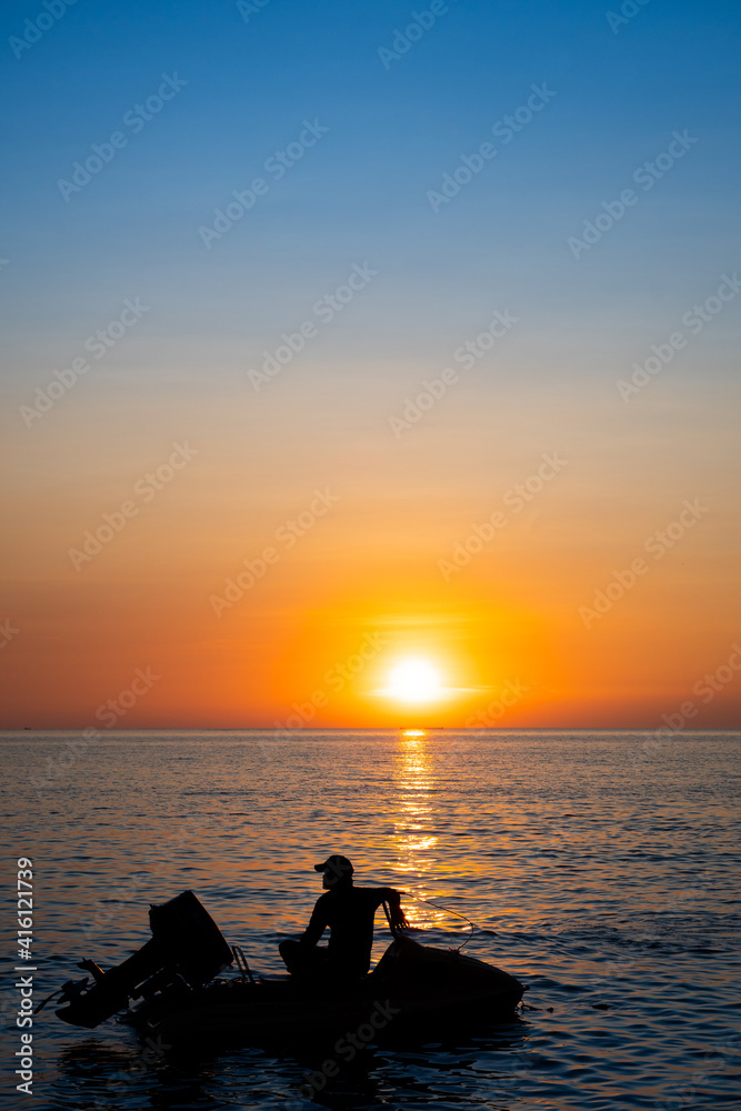 BANGSAN BEACH, CHONBURI, THAILAND, NOV 18, 2020 : silhouette of umidentified man on his jetski during sunset at Bangsan Beach, November 2020