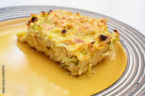 Baked chicken and mushroom cannelloni, bathed in cream in cheese sauce gratin on white wooden background