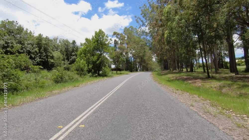 Rear facing driving point of view POV of a deserted Queensland country road with tall trees and hill ascent - ideal for interior car scene green screen replacement Rear facing driving point of view POV of a deserted Queensland country road with tall trees and hill ascent - ideal for interior car scene green screen replacement