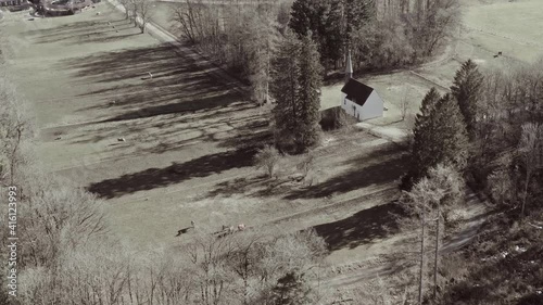 Horses at a farm from above - changing from black and white to a colorful 4K drone video of a rural landscape. photo