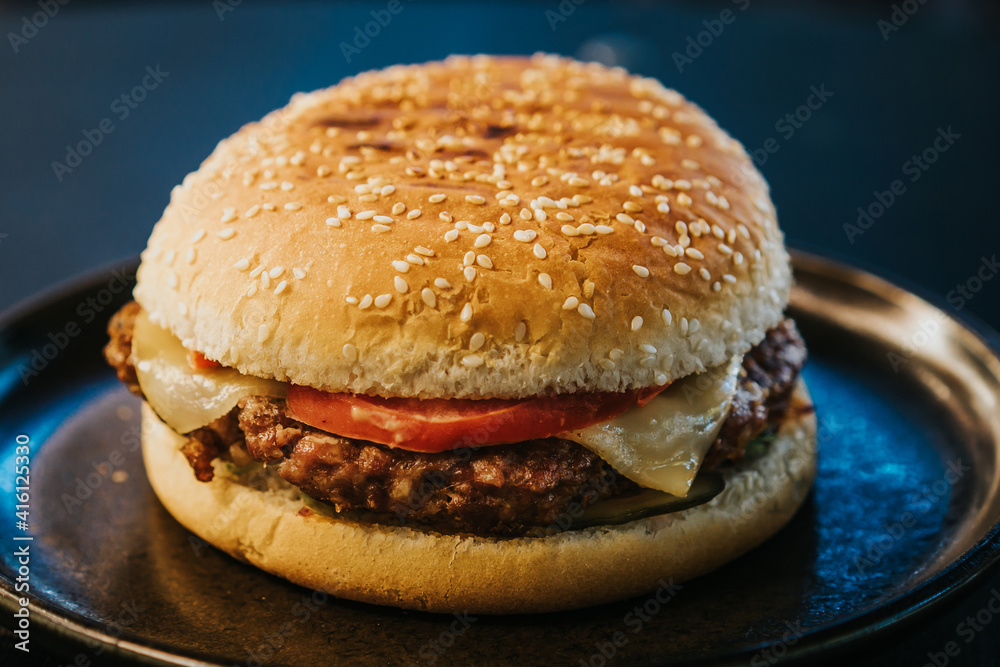 Cheesburger with grilled beef and bacon on black plate
