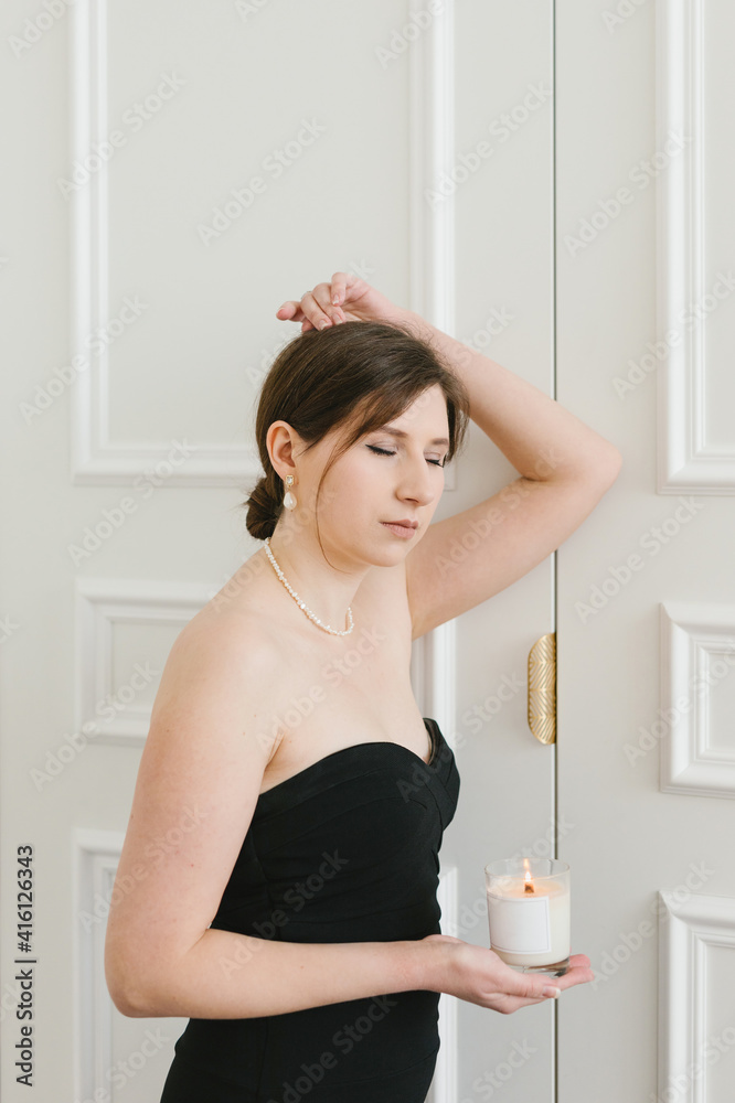 A girl in a black dress with candles in her hands. The concept of comfort, style. A girl in a black dress with candles in her hands. The concept of comfort, style.