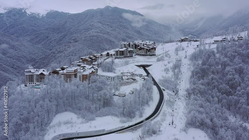 panorama of Rosa Khutor on a frosty winter day. Fly above winter snow covered trees. photo