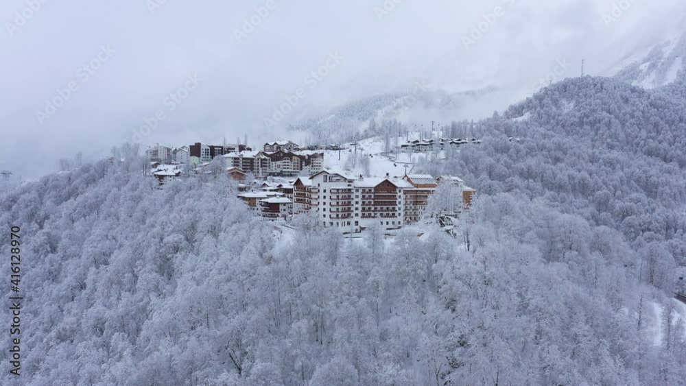 panorama of Rosa Khutor on a frosty winter day. Fly above winter snow covered trees.