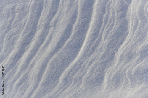 Snow surface wavy texture. Snowdrift. Snow dunes.