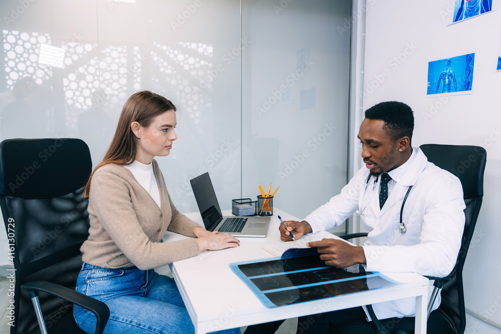 Obraz premium a woman patient at the doctor's appointment, he writes in the questionnaire a course of treatment, taking pills