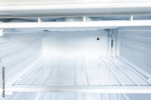 domestic fridge freezer defrost problem concept. refrigerator covered with ice. appliance repair concept