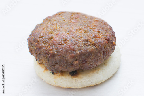 Seasoned meatloaf served with corn arepa on white wooden background