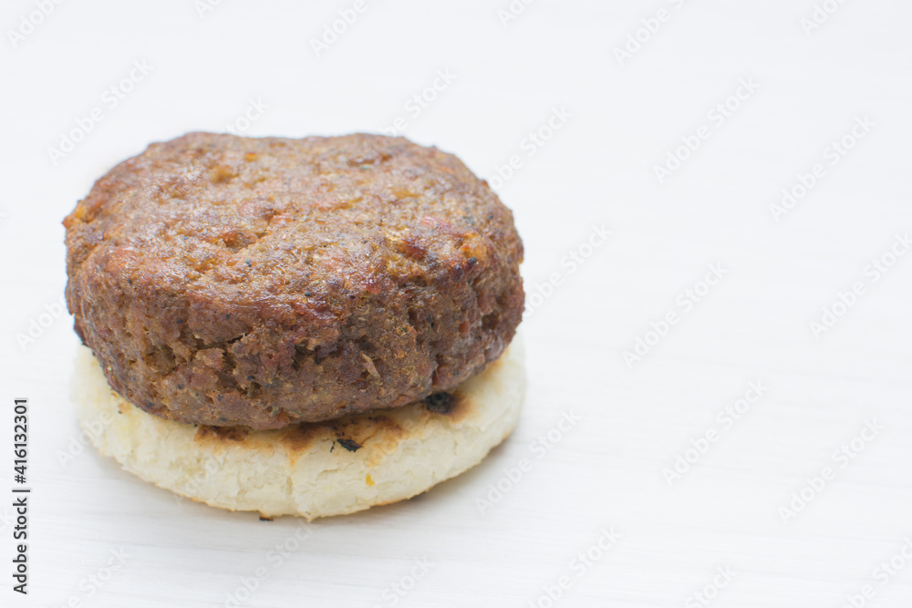 Seasoned meatloaf served with corn arepa on white wooden background Seasoned meatloaf served with corn arepa on white wooden background