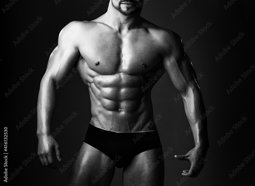 Man with muscular body and torso. Sportsman with bare chest in pants. Sport and workout. Athletic bodybuilder man on black background. Man with muscular body and torso. Sportsman with bare chest in pants. Sport and workout. Athletic bodybuilder man on black background.
