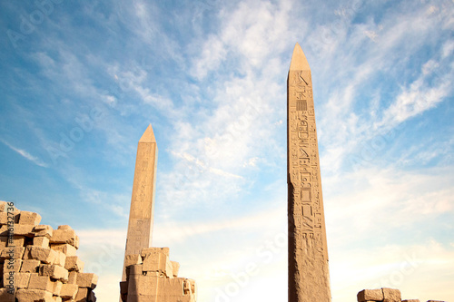 Fototapeta two pylons and a lot of ruin stones with cloudy blue sky , Luxor Karnak temple