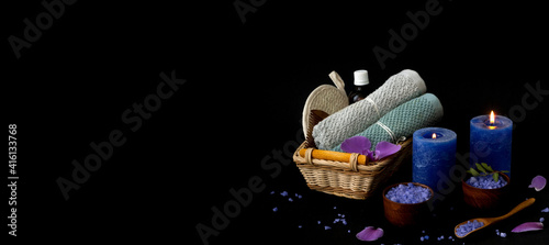 Spa and beauty treatment products on dark  background. Spa composition with light candles. Lavender salt for spa treatments on wooden background. Creative copy space.