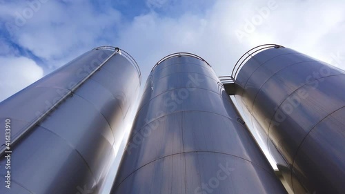 Large metal silo for storing raw material. Modern industrial plant.