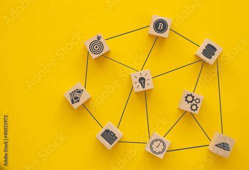 Network. Wooden blocks connected together on a yellow background. Teamwork concept