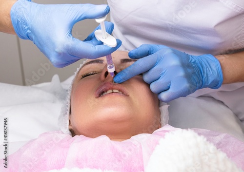 Cosmetology, lip augmentation, beauty injections in a beauty salon, close up