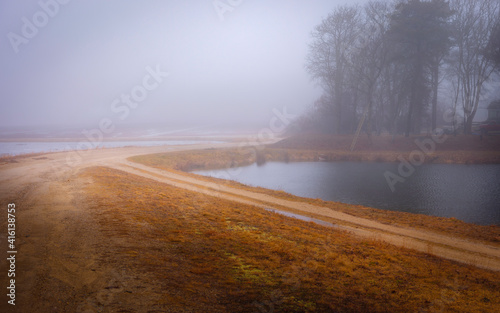 Foggy Landscape of Curved Dirt Road, Pond, Forest, and Farm Land