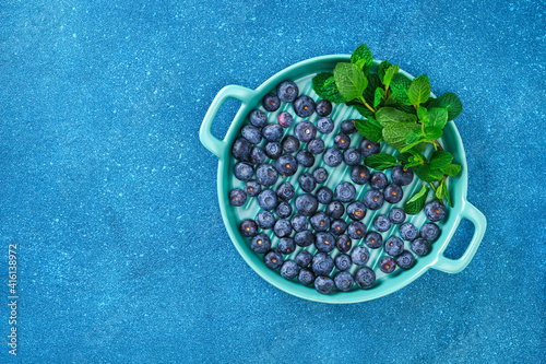 Blueberries, bog whortleberry, great biberry on a blue background. Top view.