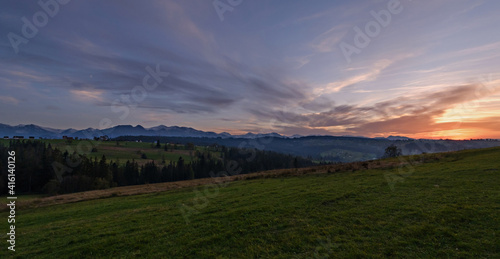 Wide panorama view of snowy Tatra Mountains national park with sunset colorful dramatic sky. Poland, Slovakia